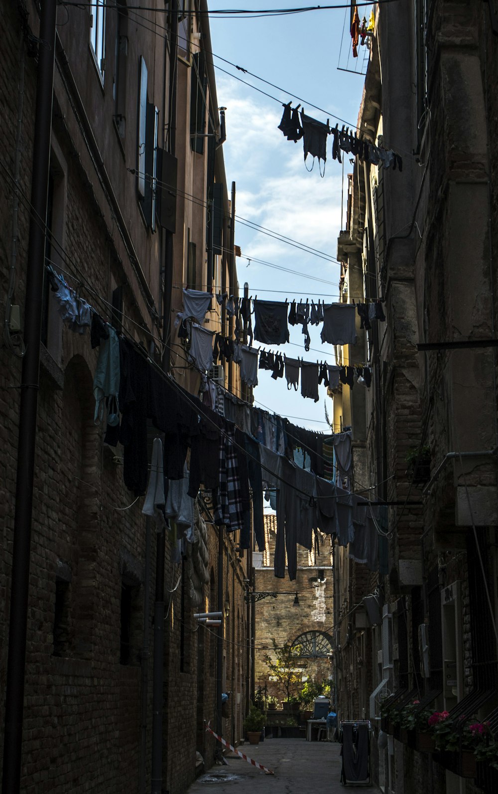a narrow alley way with clothes hanging out to dry