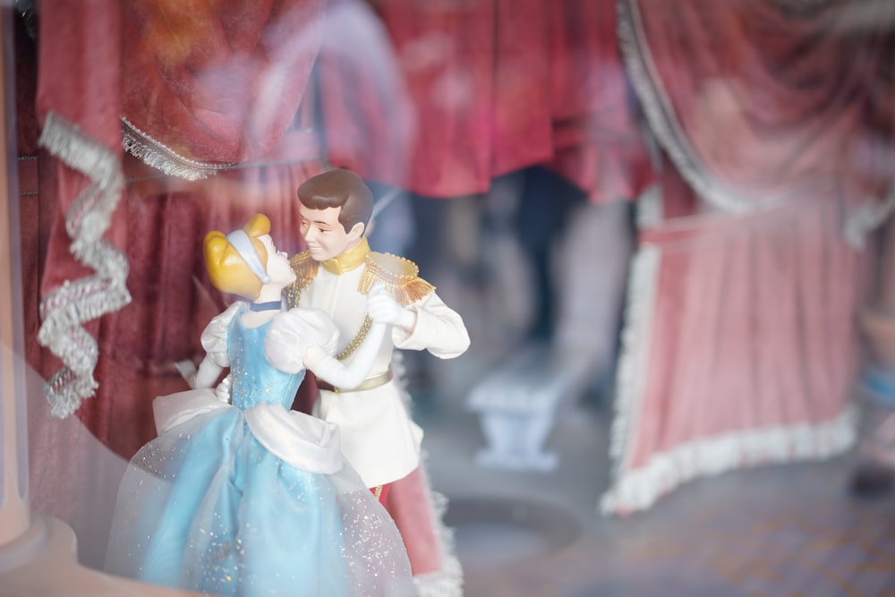 Figura de Cenicienta y Príncipe Azul bailando en fotografía de enfoque selectivo
