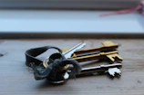 A collection of worn-out keys tangled together on a rustic table.