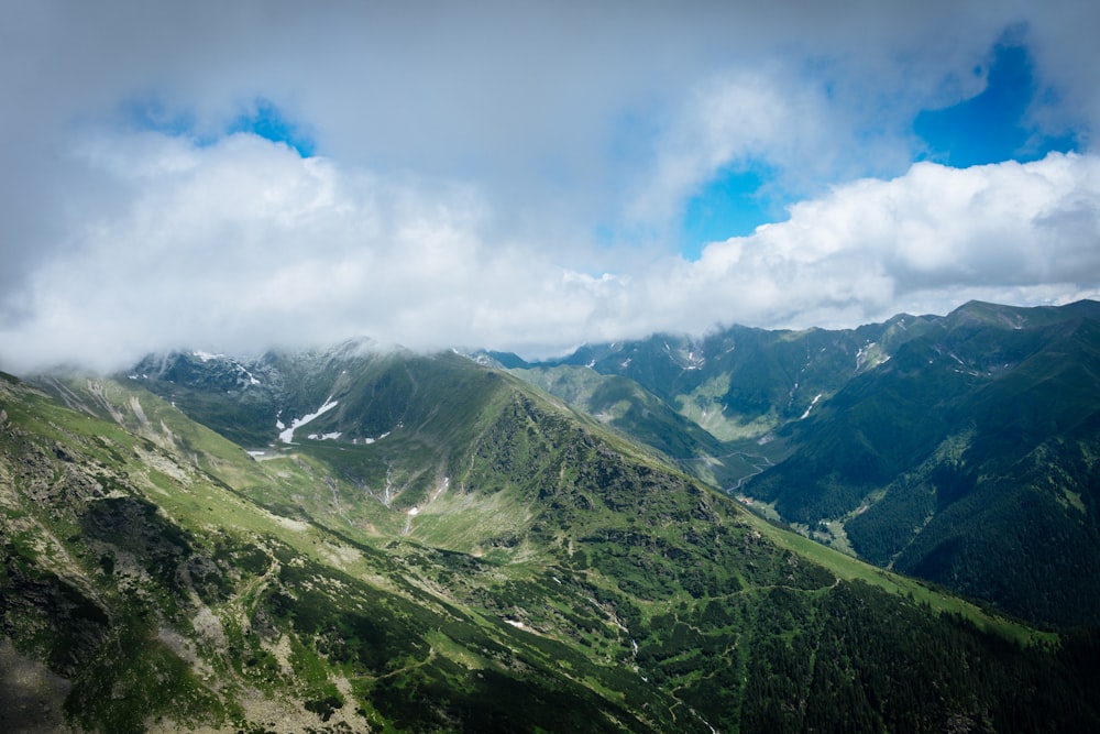 green mountains under blue sky and white clouds during daytime