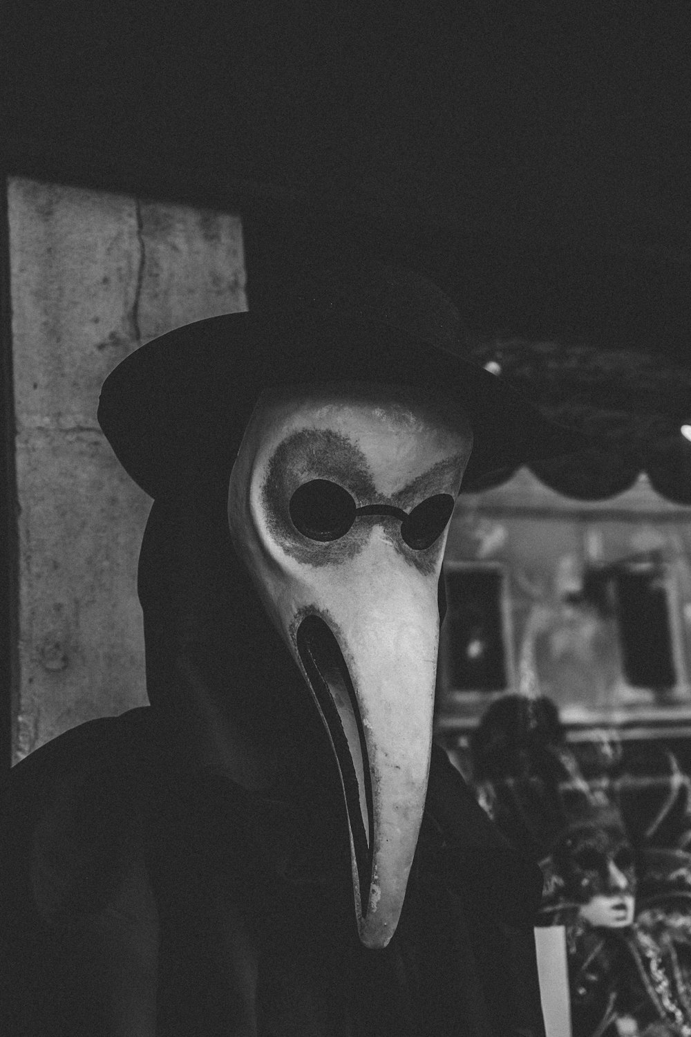 grayscale photo of man wearing gray mask