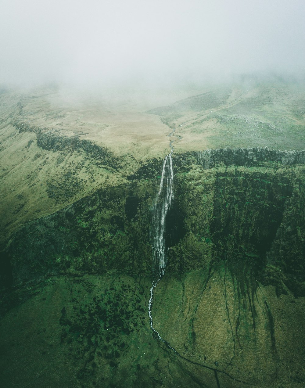 aerial photo of waterfalls during foggy weather