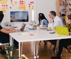 five person by table watching turned on white iMac