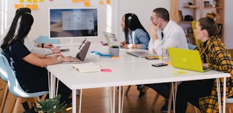 five person by table watching turned on white iMac