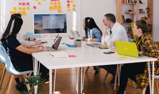 five person by table watching turned on white iMac