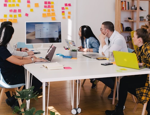 five person by table watching turned on white iMac