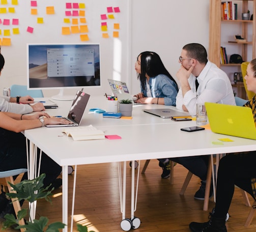 five person by table watching turned on white iMac