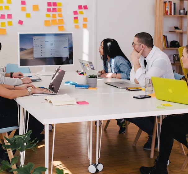 five person by table watching turned on white iMac