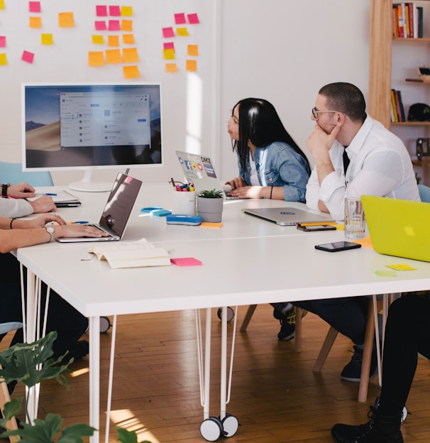 five person by table watching turned on white iMac