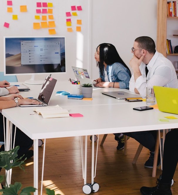 five person by table watching turned on white iMac