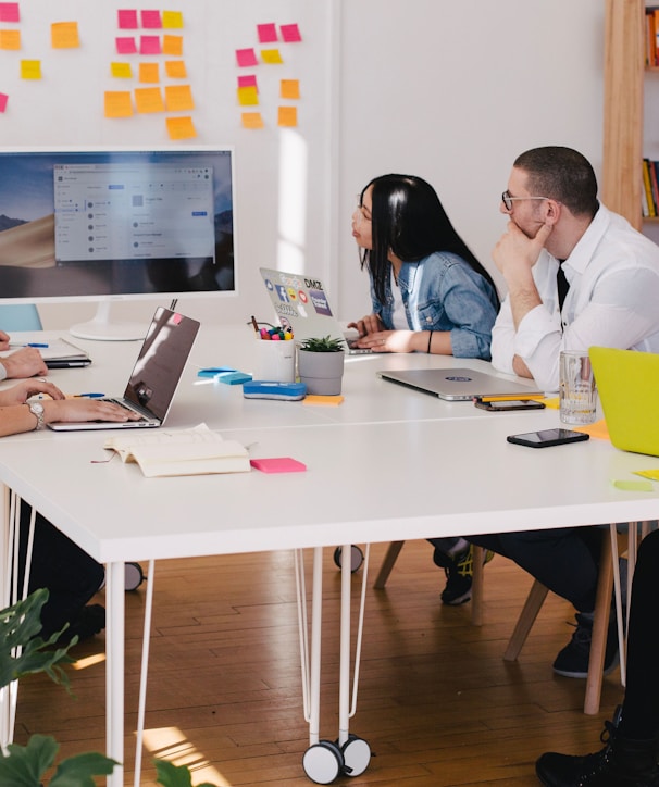 five person by table watching turned on white iMac