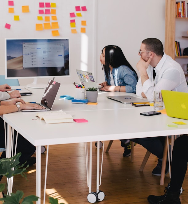 five person by table watching turned on white iMac