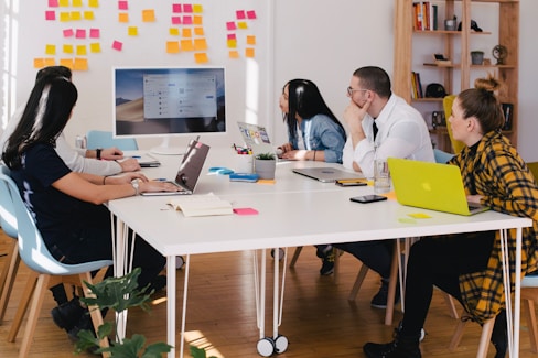 five person by table watching turned on white iMac