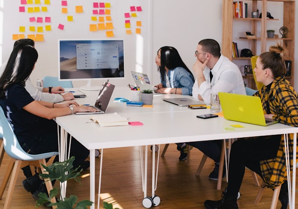 five person by table watching turned on white iMac