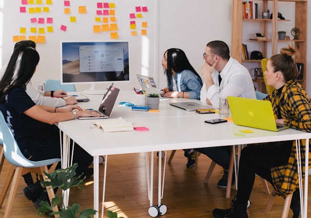 five person by table watching turned on white iMac