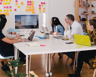 five person by table watching turned on white iMac