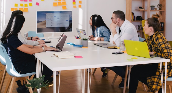 five person by table watching turned on white iMac