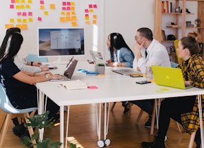 five person by table watching turned on white iMac