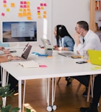 five person by table watching turned on white iMac