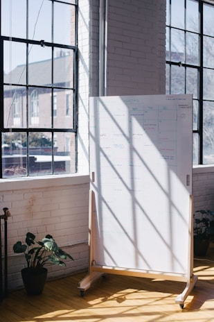 A bright room with sunlight streaming in, showing a whiteboard with blog ideas and sketches.