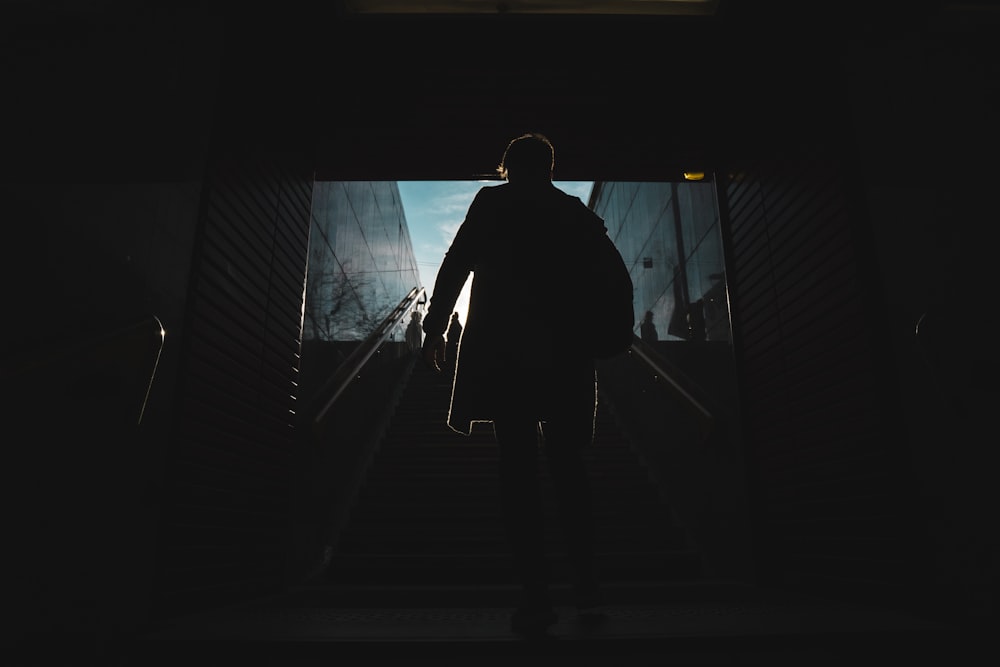 a man walking up a flight of stairs at night