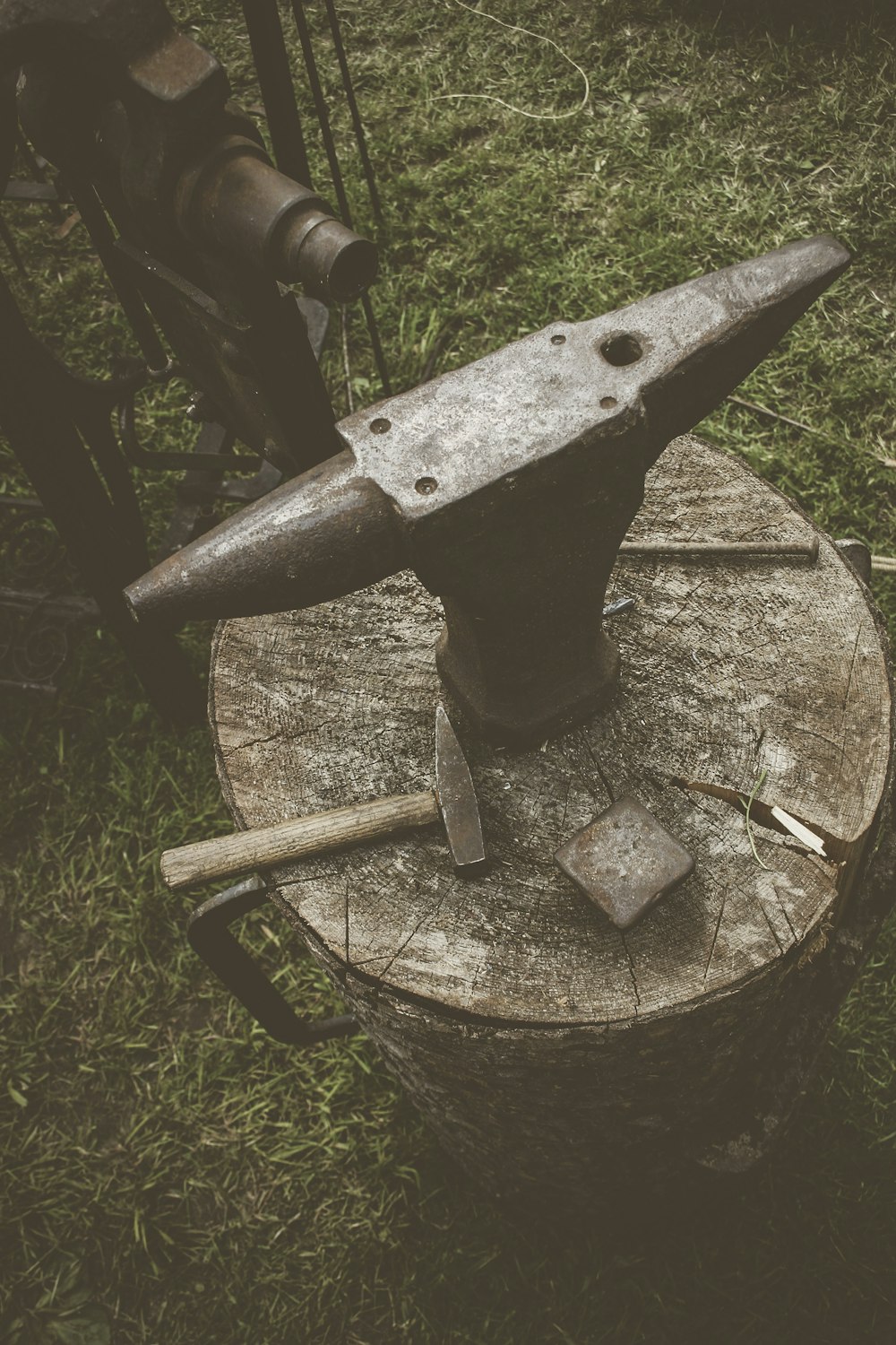metal anvil on cut log with hammers