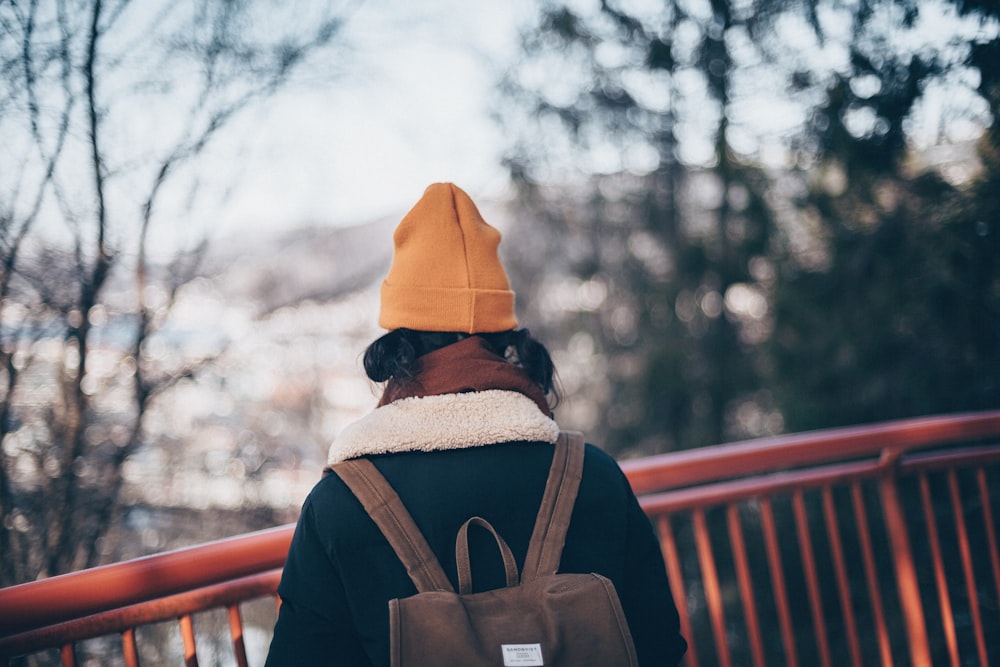 selective focus photography of woman standing near green leaf trees