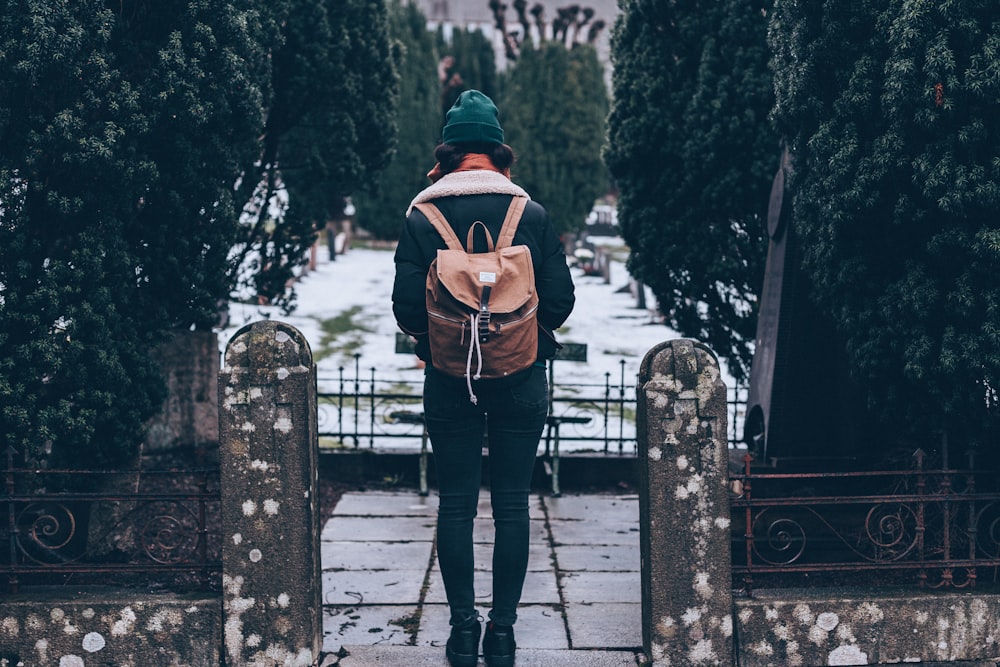 woman standing on pathway carrying backpack