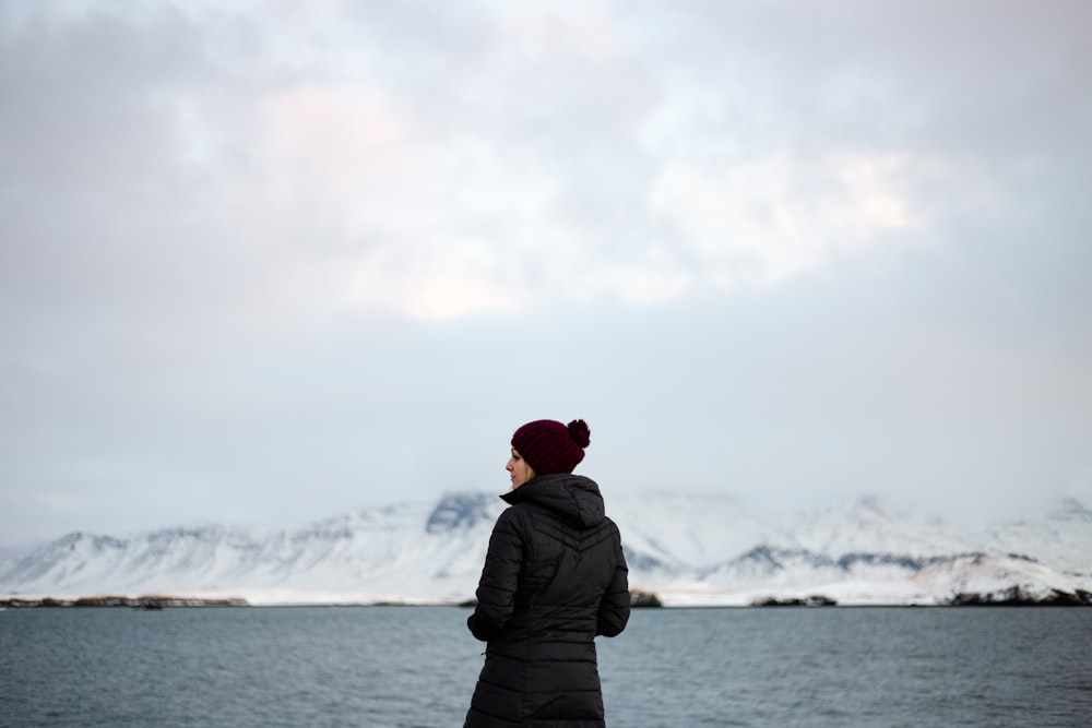 바다 근처에서 겨울 코트를 입고 있는 여자