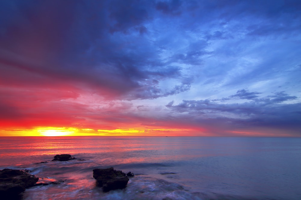 calm sea with rocks during golden hour