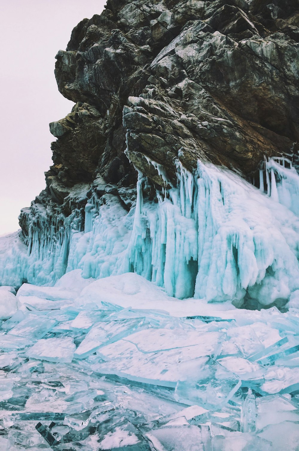 brown rock formation beside ice during daytime