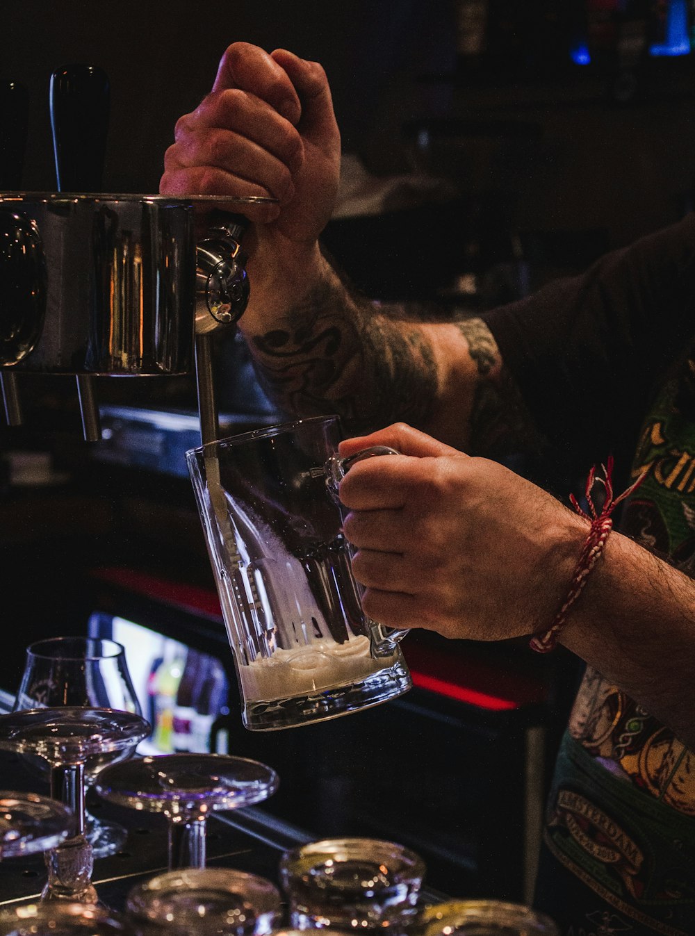 personne tenant une chope de bière en verre transparent