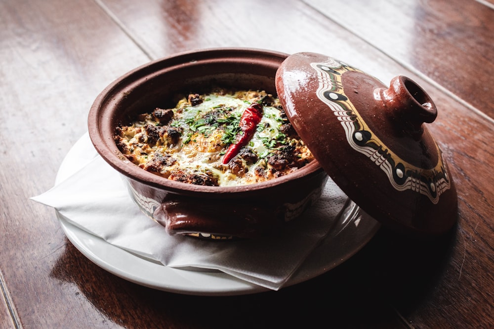 Olla redonda de cerámica marrón y blanca con comida