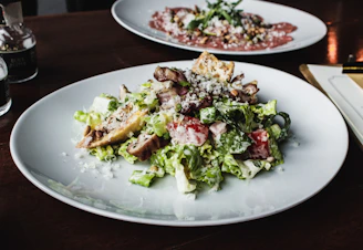 A vibrant salad plate featuring mixed greens, grilled chicken, and a sprinkle of cheese.