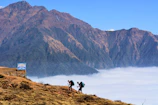 Adventurous travelers hiking on a vibrant mountain trail with panoramic views
