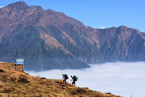 Tourists hiking a rugged trail with panoramic views of Vancouver’s mountains in the background.