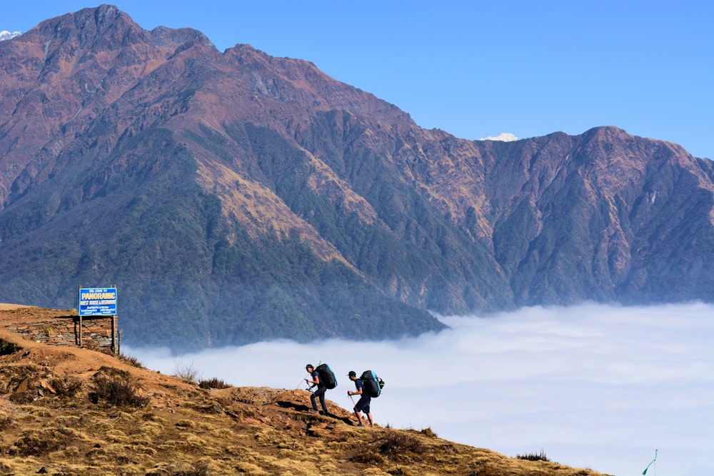 two person walking near mountain