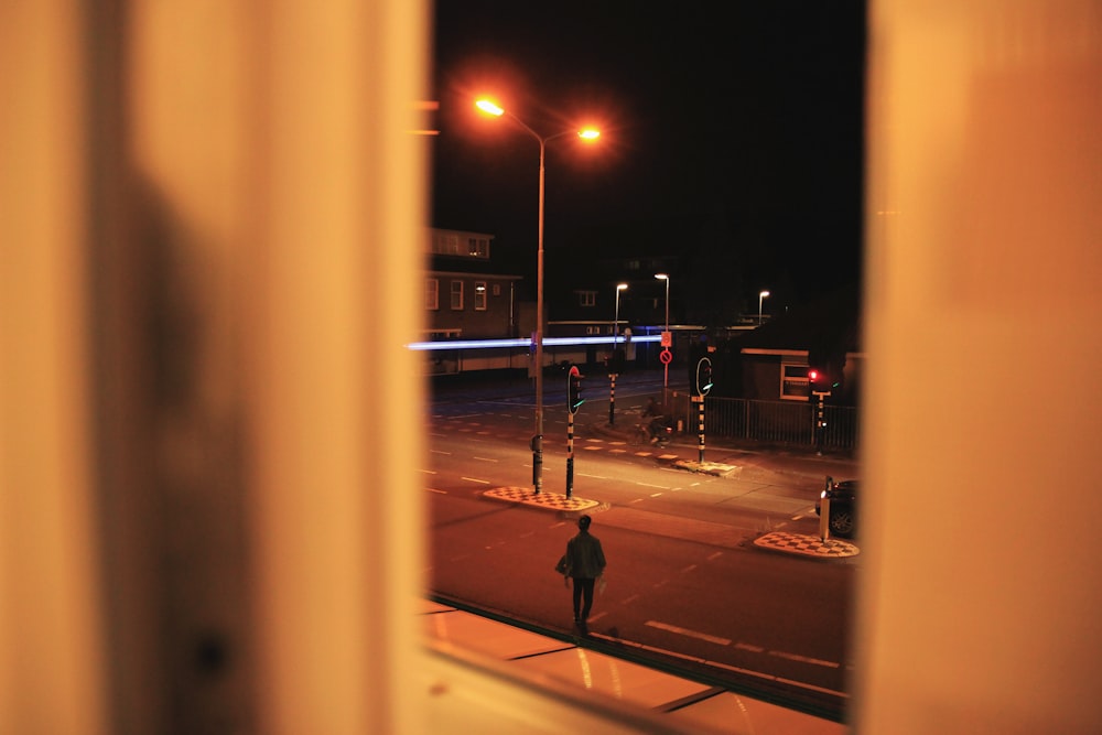 man walking on road during nighttime