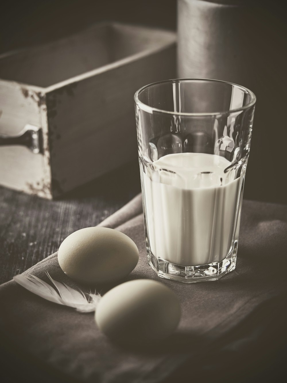 two organic eggs and glass of milk on textile