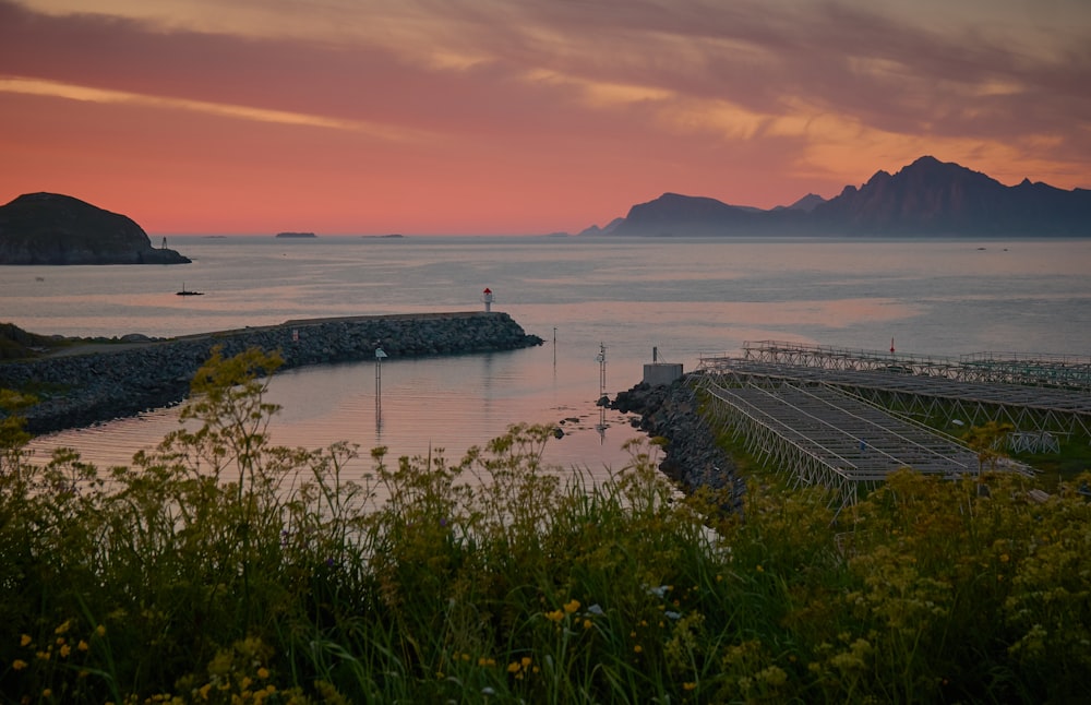 Mar en calma junto a la montaña y muelles durante la hora dorada