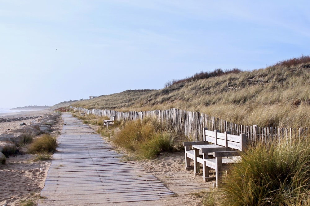 a wooden path leading to a sandy beach