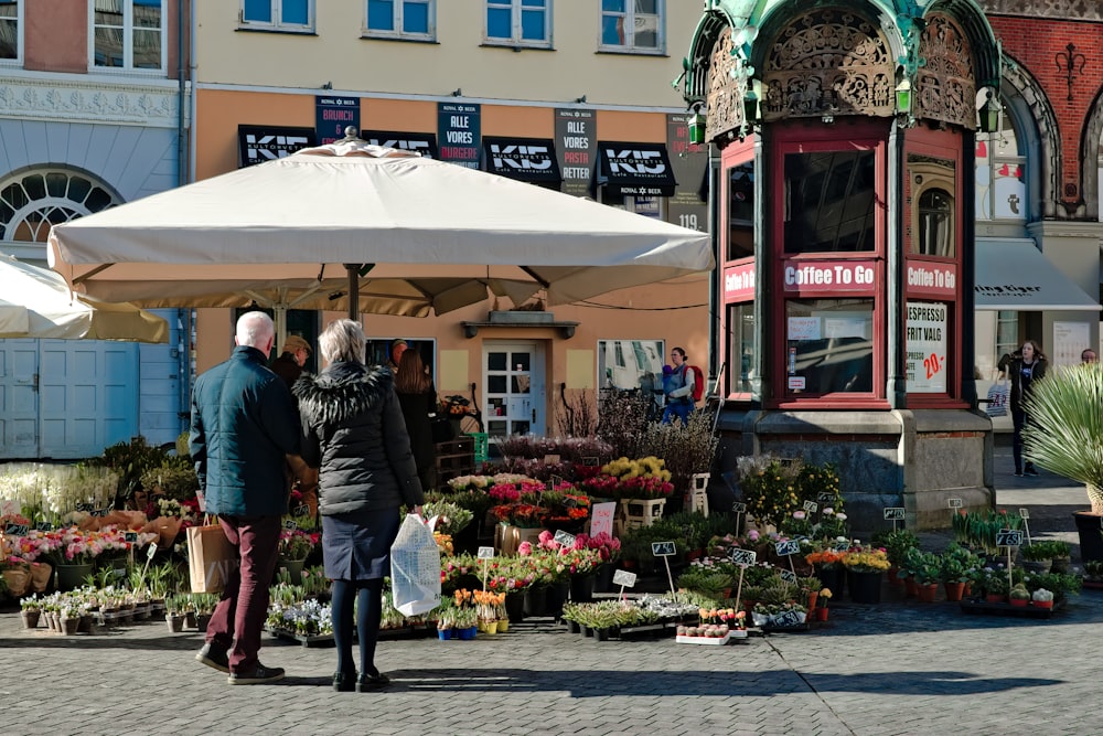 man and woman standing near assorted plants