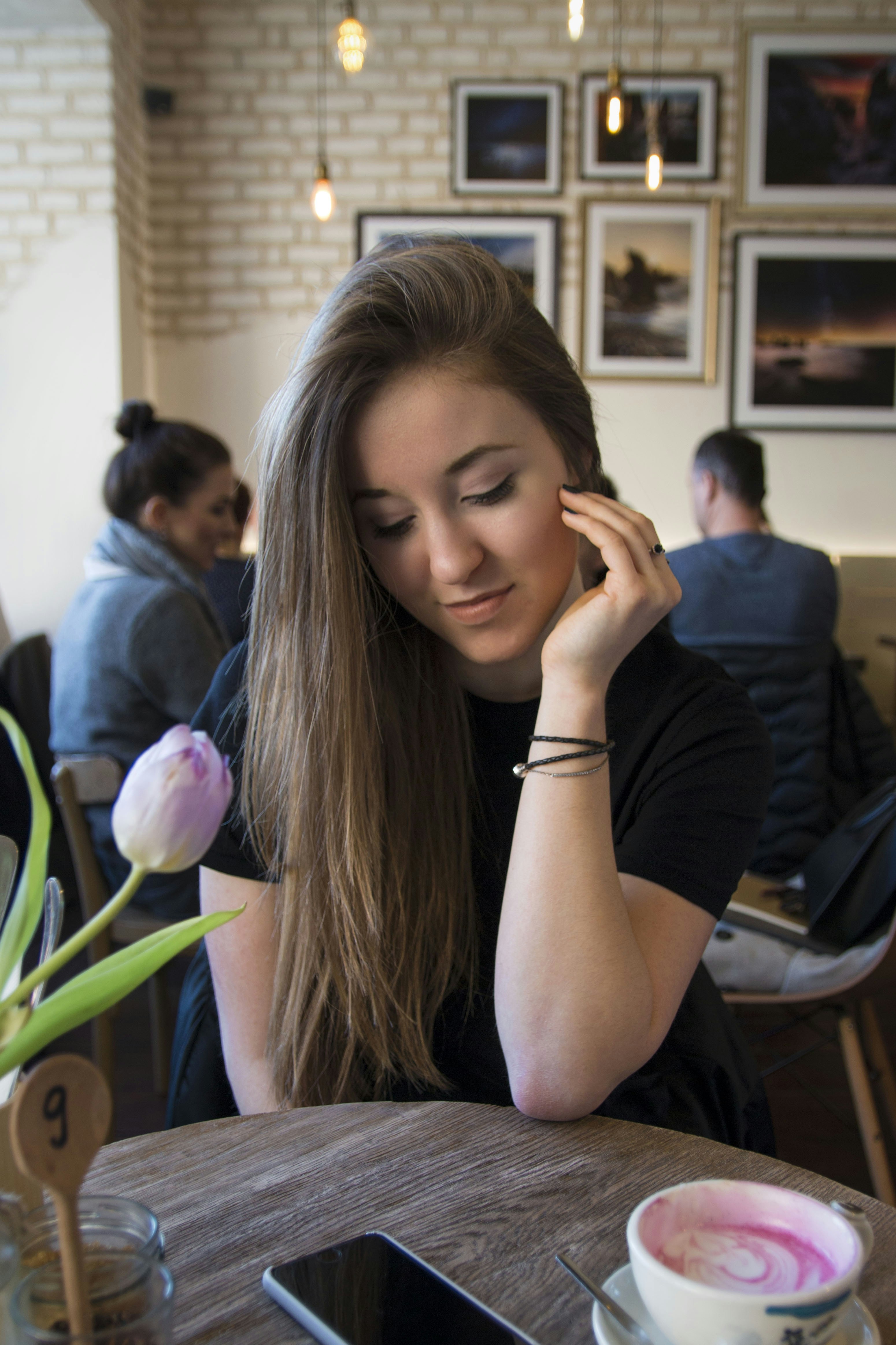 Portrait of a smiling young woman reading a blog post on her tablet in a cozy café.