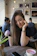 Portrait of a smiling young woman using a smartphone in a bright, modern cafe.