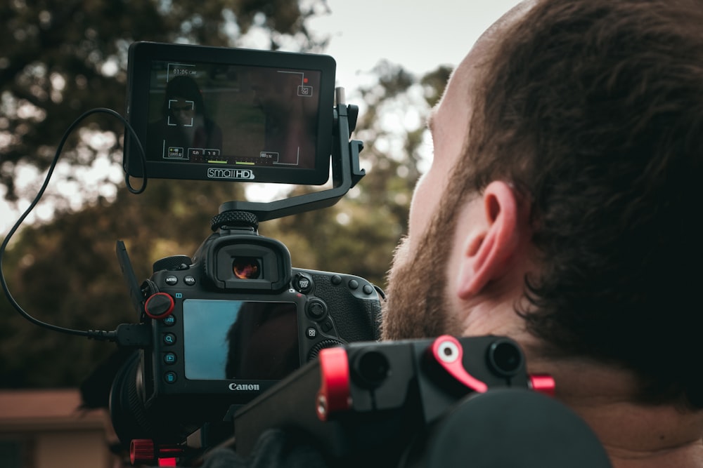 hombre tomando foto con una cámara DSLR