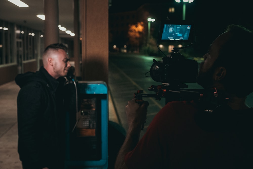 man holding camera during nighttime