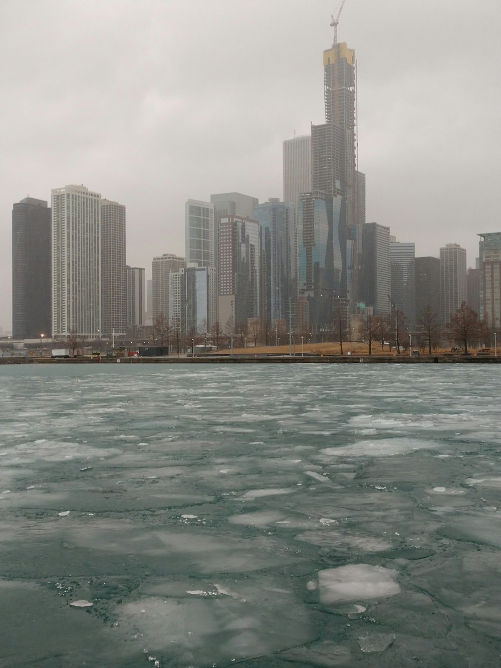 a large body of water with ice in front of a city