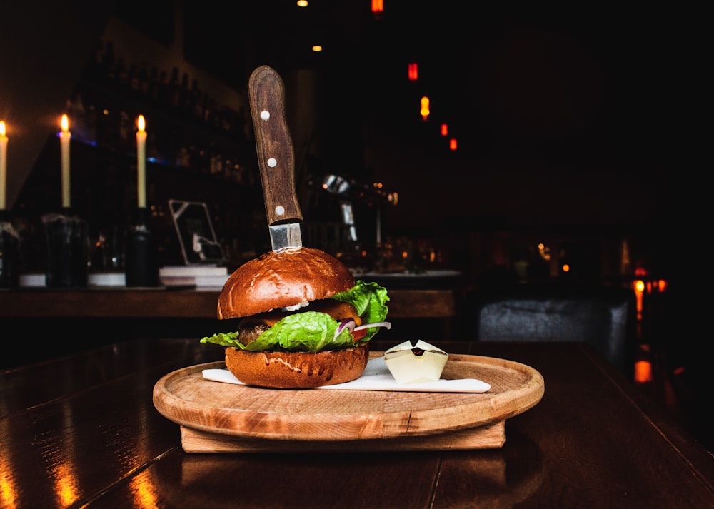 selective focus photography of burger on brown wooden tray