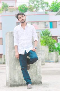 Side profile of a man leaning against a concrete wall, dressed in layered terravibe pieces with warm sand accents.