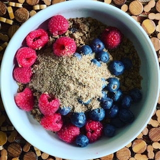 A vibrant single-serving breakfast bowl with fresh berries and granola on a clean white plate.